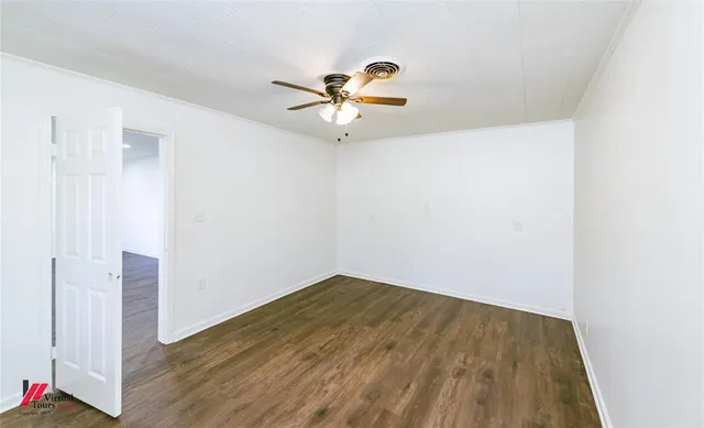a view of a room with wooden floor and a ceiling fan