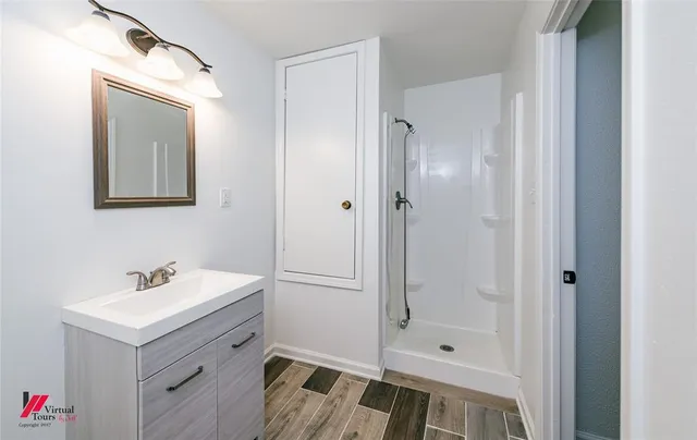 a bathroom with a shower sink and mirror