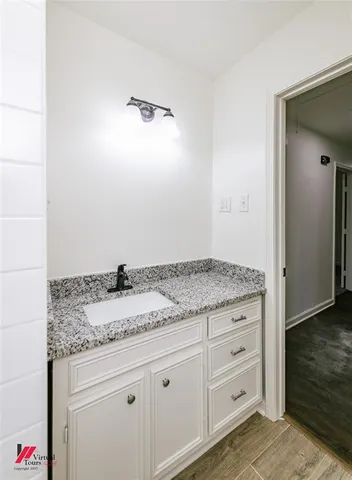 a bathroom with a granite countertop sink and vanity
