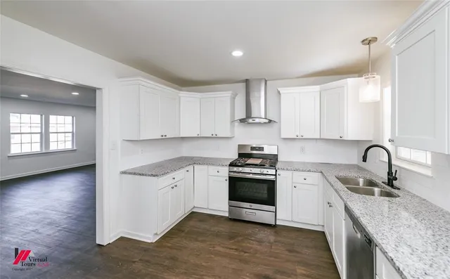 a kitchen with stainless steel appliances granite countertop a sink stove and cabinets