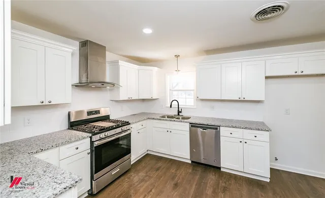 a kitchen with granite countertop white cabinets and white appliances