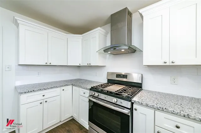 a kitchen with white cabinets and appliances