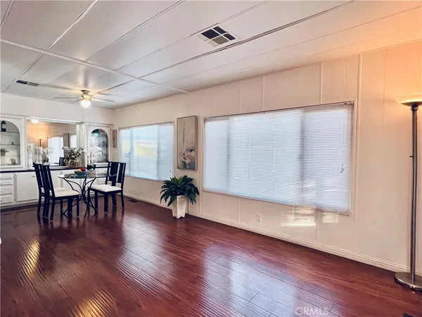 a dining room with furniture potted plants and wooden floor