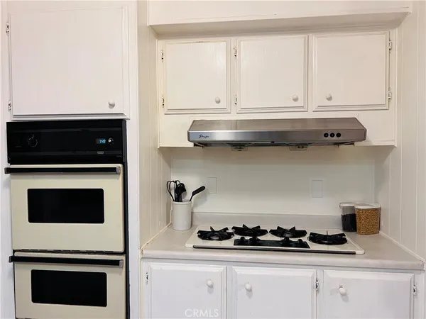 a view of a kitchen with wooden floor and electronic appliances