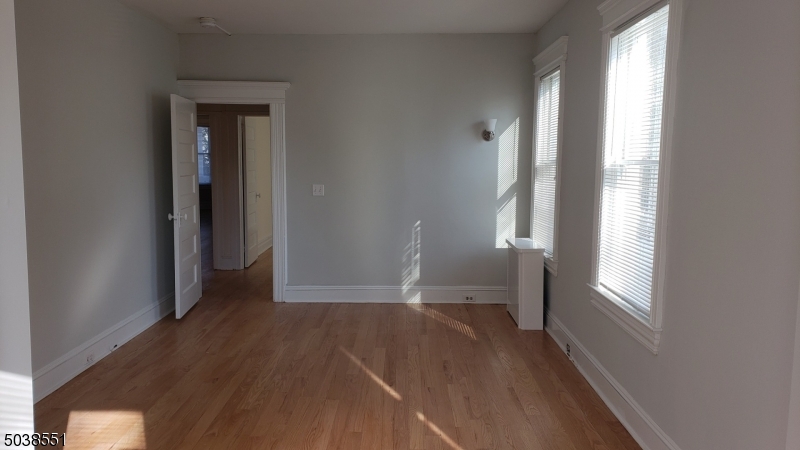 16 Munn Street, Unit 1 Montclair, NJ 07042 - Photo 12 of 22 an empty room with wooden floor and windows