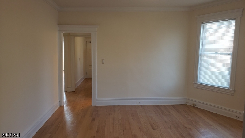 16 Munn Street, Unit 1 Montclair, NJ 07042 - Photo 6 of 22 an empty room with wooden floor and windows