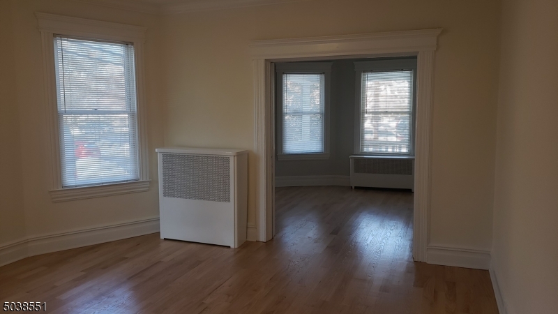 16 Munn Street, Unit 1 Montclair, NJ 07042 - Photo 7 of 22 an empty room with wooden floor and windows