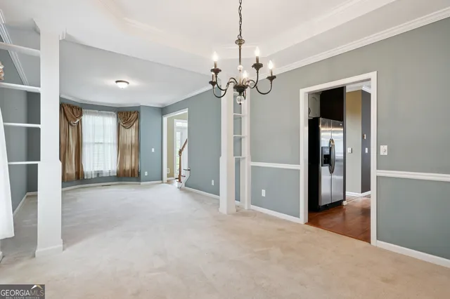 a view of a livingroom with a chandelier fan and windows