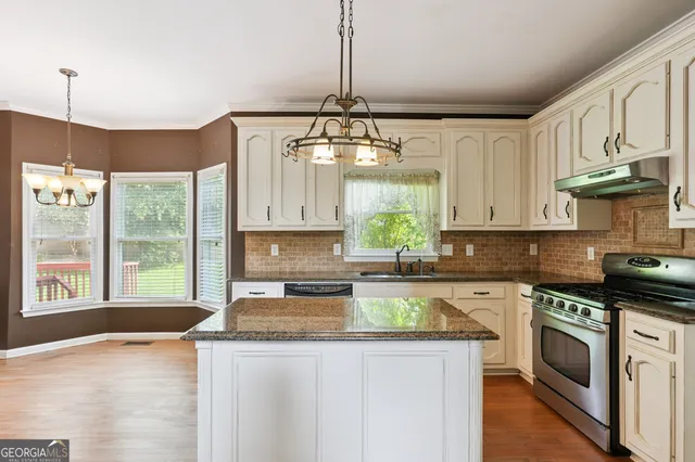 a kitchen with a stove a sink a center island and cabinets