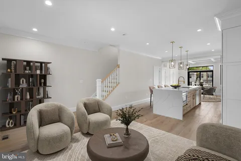 a living room with furniture kitchen view and a chandelier