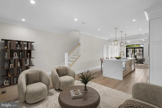 a living room with furniture kitchen view and a chandelier