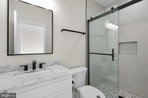 a bathroom with a granite countertop sink toilet and shower