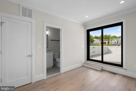 a view of a big room with wooden floor and windows