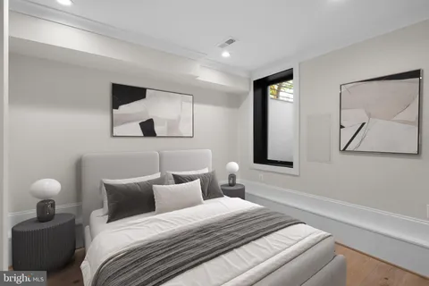 a bedroom with a bed and a painting on the wall