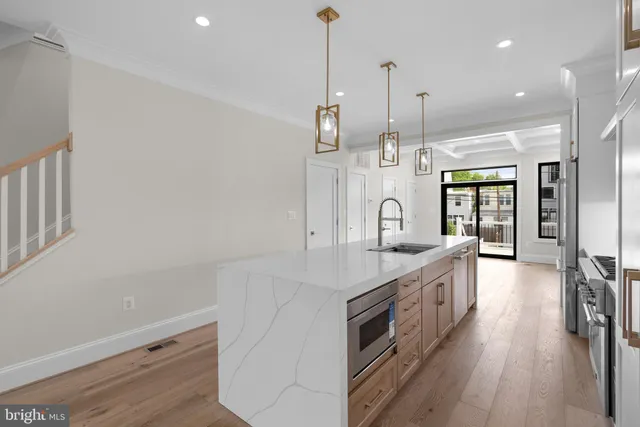 a kitchen with stainless steel appliances granite countertop a sink and a wooden floor