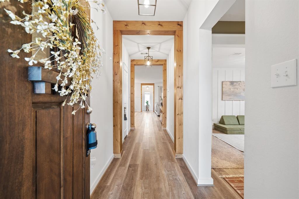 a view of a hallway with wooden floor and entryway
