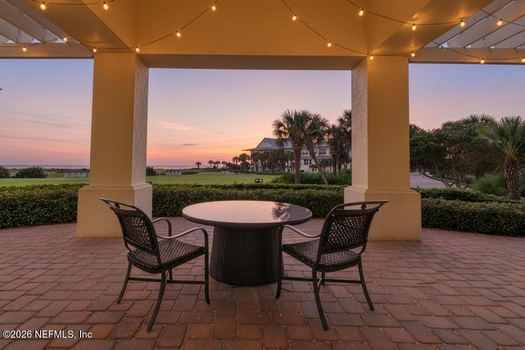 320 Ocean Crest Drive Palm Coast, FL 32137 - Photo 6 of 93 a view of a patio with table and chairs with wooden floor and fence