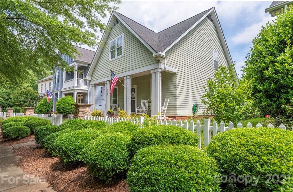 a view of a house with potted plants and large trees