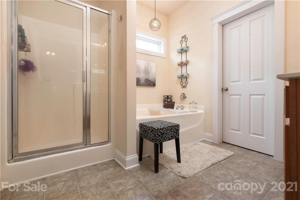 8237 Bud Henderson Road Huntersville, NC 28078 - Photo 15 of 25 a bathroom with a granite countertop sink a mirror and a shower