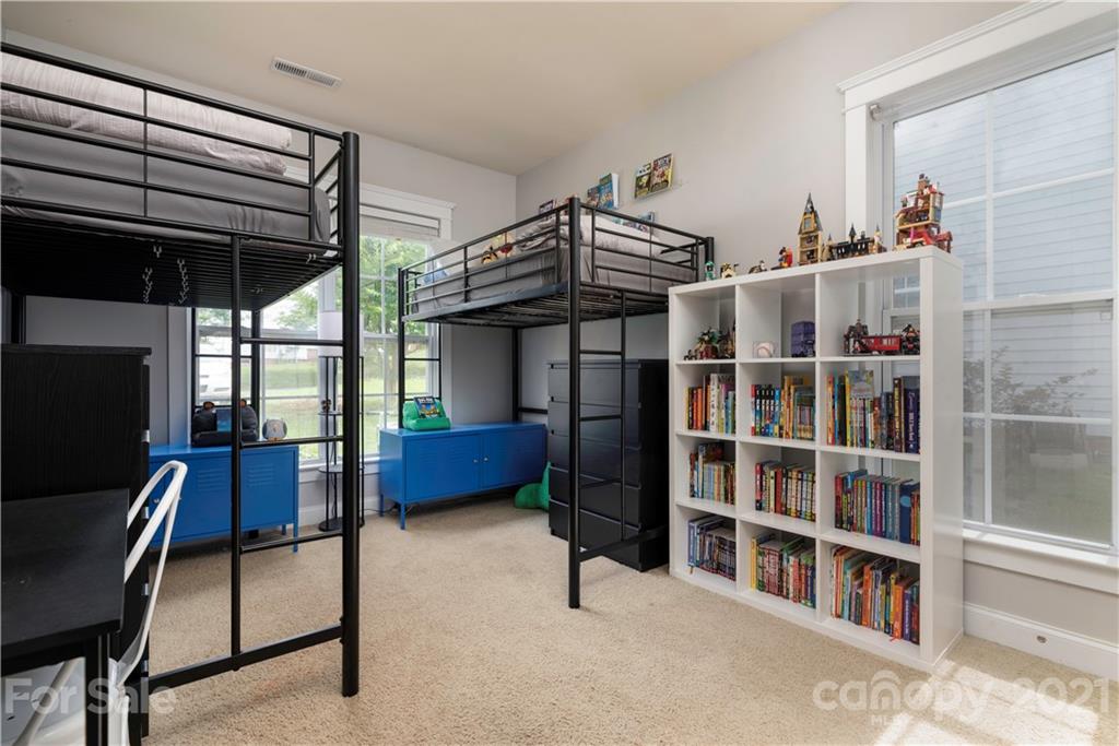 8237 Bud Henderson Road Huntersville, NC 28078 - Photo 18 of 25 a bedroom with furniture and a book shelf