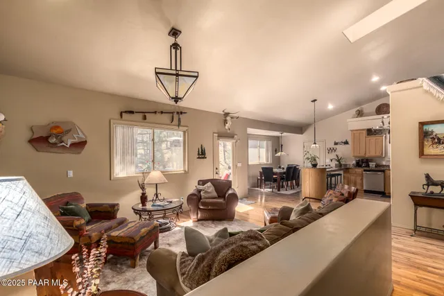 a living room with furniture a dining table and a chandelier