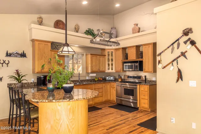 a kitchen with stainless steel appliances kitchen island granite countertop a sink and cabinets
