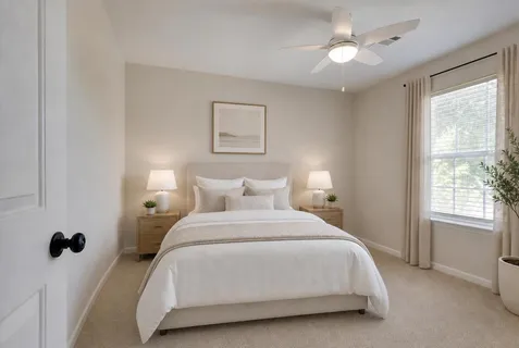 an empty room with a window and a ceiling fan