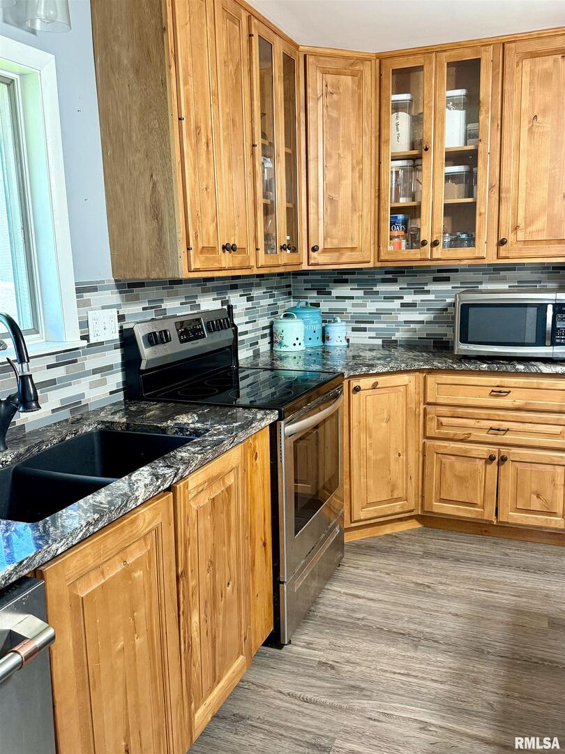 824 9th Avenue Fulton, IL 61252 - Photo 10 of 22 a kitchen with stainless steel appliances granite countertop wooden cabinets a sink and a wooden floor