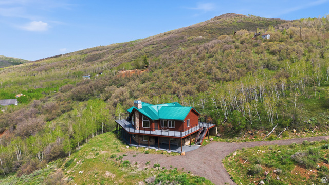 6 Beaver Springs Rancheros Oakley, UT 84055 - Photo 53 of 68 Rustic-style property featuring a green metal roof, stone accents, and a spacious wrap-around deck