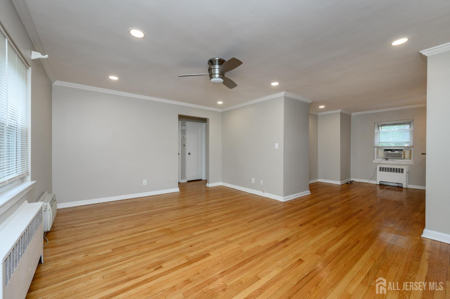 243 Johnson Avenue, Unit L5 Hackensack, NJ 07601 - Photo 5 of 24 a view of an empty room with wooden floor and a window