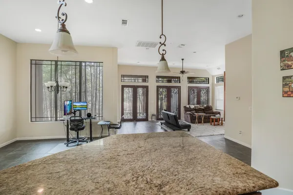 a view of a livingroom with furniture a rug a chandelier and wooden floor