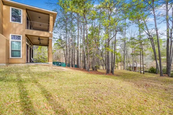 a view of an house with backyard and trees