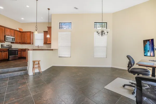 a room with stainless steel appliances kitchen island granite countertop a sink refrigerator and cabinets