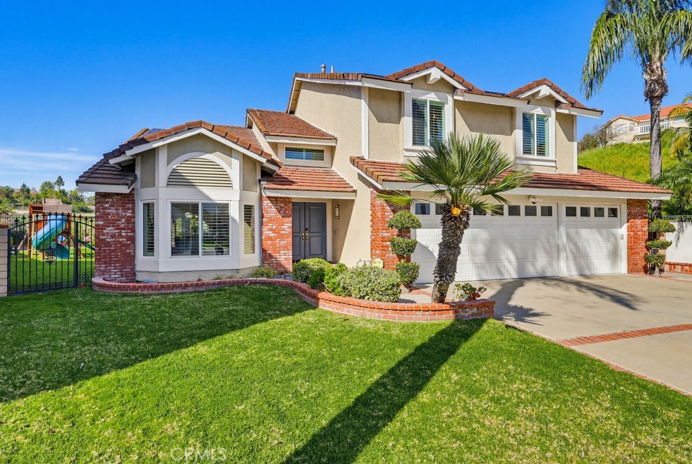 24303 East Rimford Place Diamond Bar, CA 91765 - Photo 2 of 39 a front view of a house with a yard