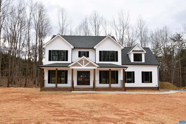 a front view of a house with yard and trees