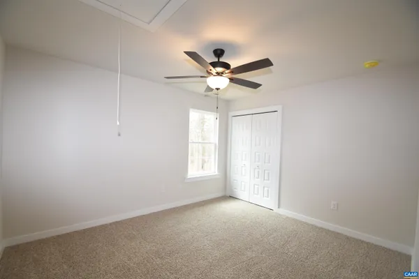 an empty room with a window and a fan