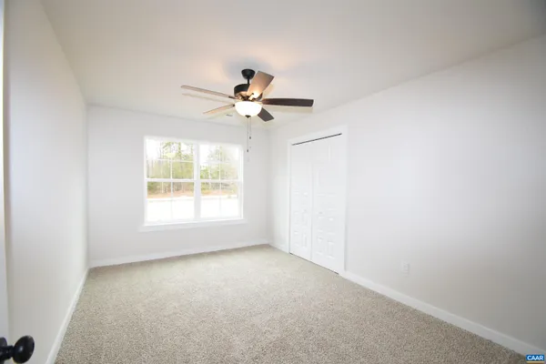 an empty room with a window and a ceiling fan