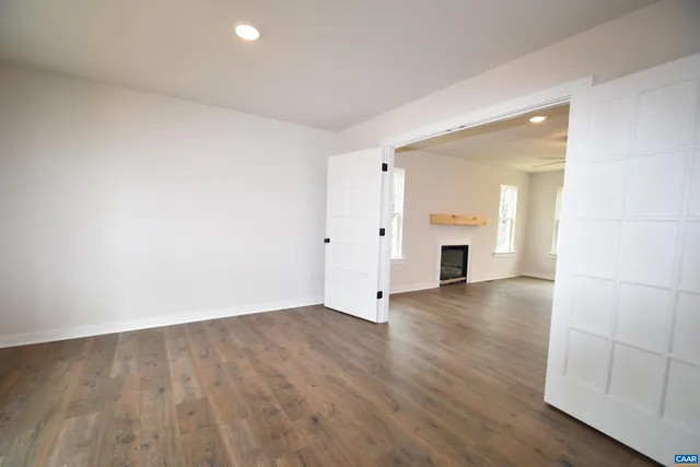 an empty room with wooden floor and fireplace