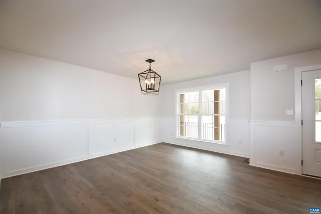 an empty room with wooden floor and window
