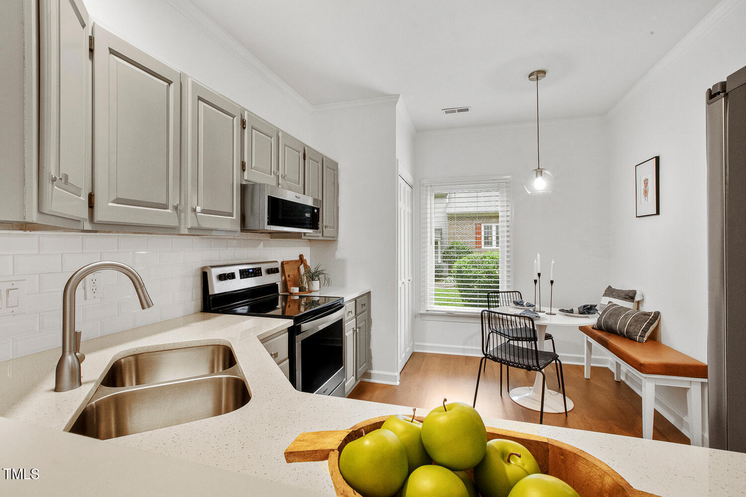 217 Danforth Drive Cary, NC 27511 - Photo 11 of 40 a kitchen with stainless steel appliances granite countertop a sink a stove and a dining table with chairs