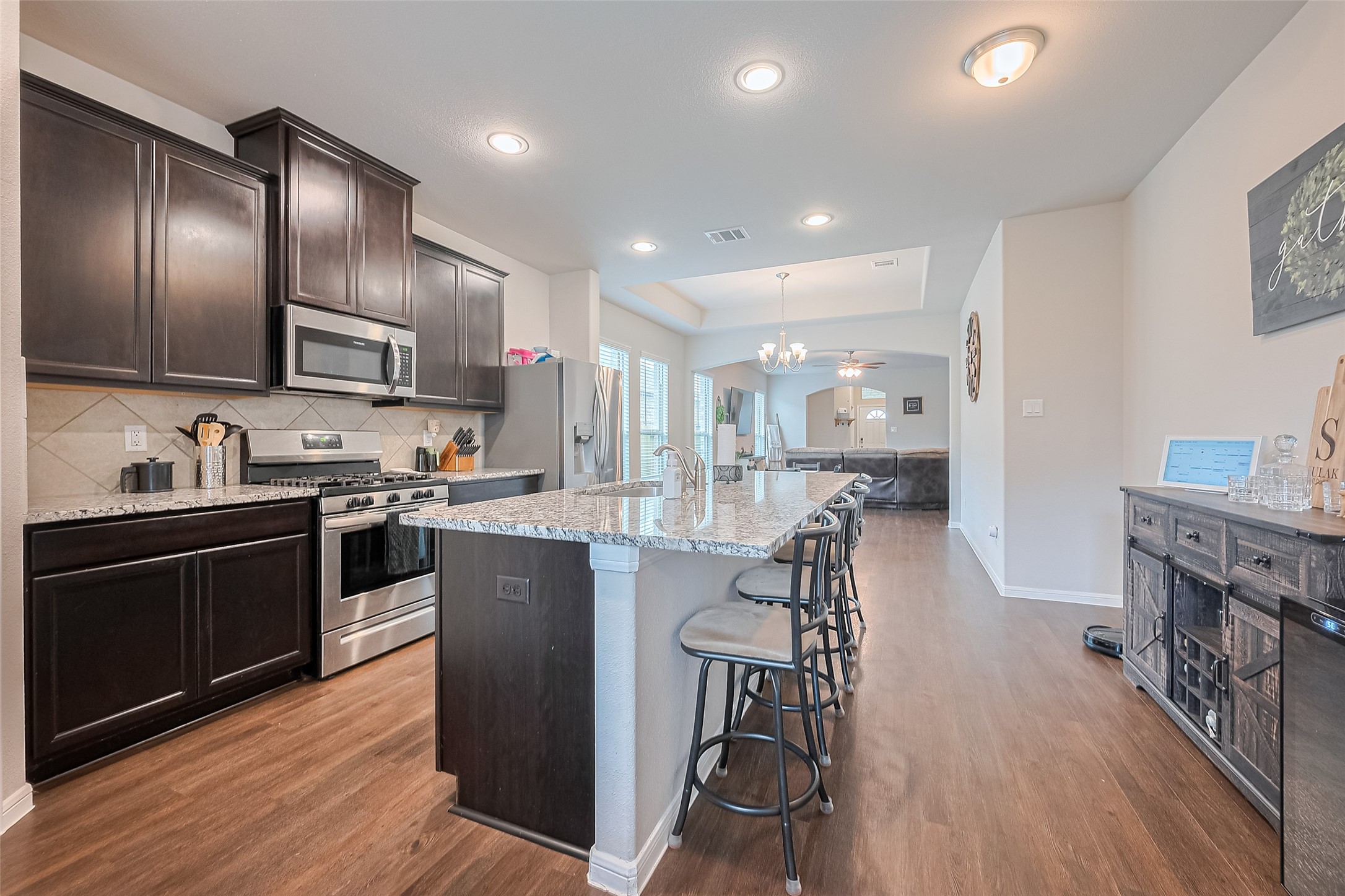1214 Red Hills Drive Rosharon, TX 77583 - Photo 12 of 46 a kitchen with stainless steel appliances granite countertop a refrigerator a stove top oven a sink dishwasher and white cabinets with wooden floor