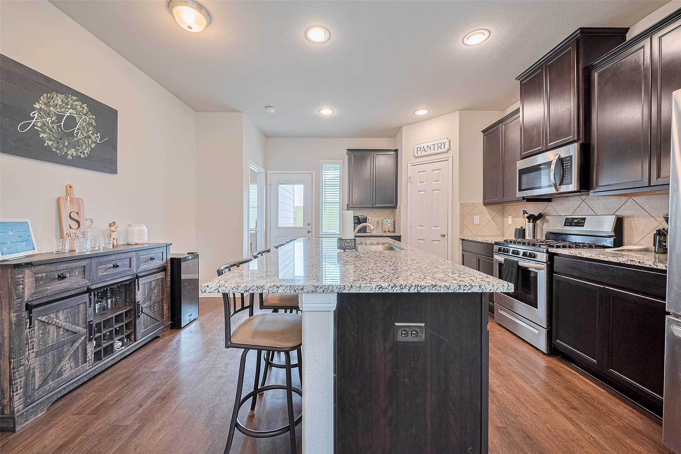 1214 Red Hills Drive Rosharon, TX 77583 - Photo 10 of 46 a kitchen with stainless steel appliances granite countertop a sink a stove and a wooden floors