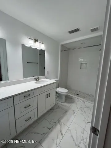 a bathroom with a double vanity sink mirror and toilet