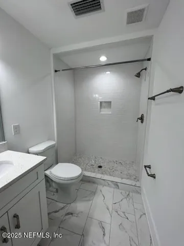 a bathroom with a sink a toilet and shower