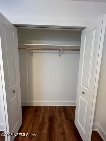 a view of walk in closet with empty racks