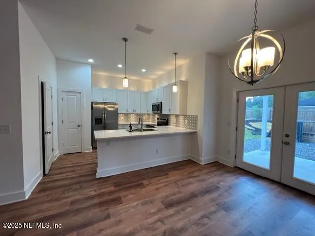 a view of kitchen with sink microwave and refrigerator