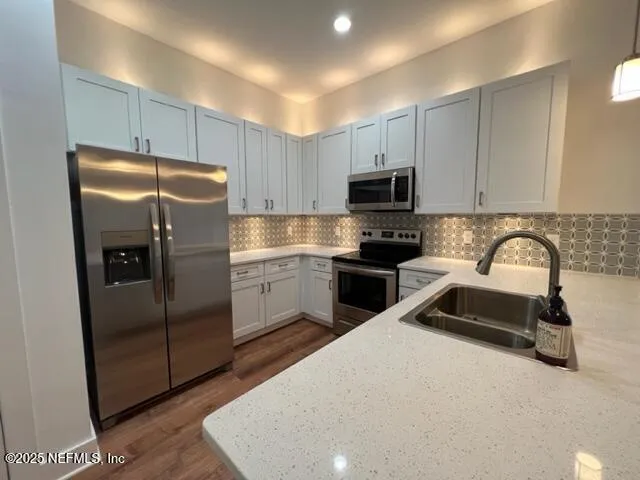a kitchen with granite countertop a refrigerator and a sink