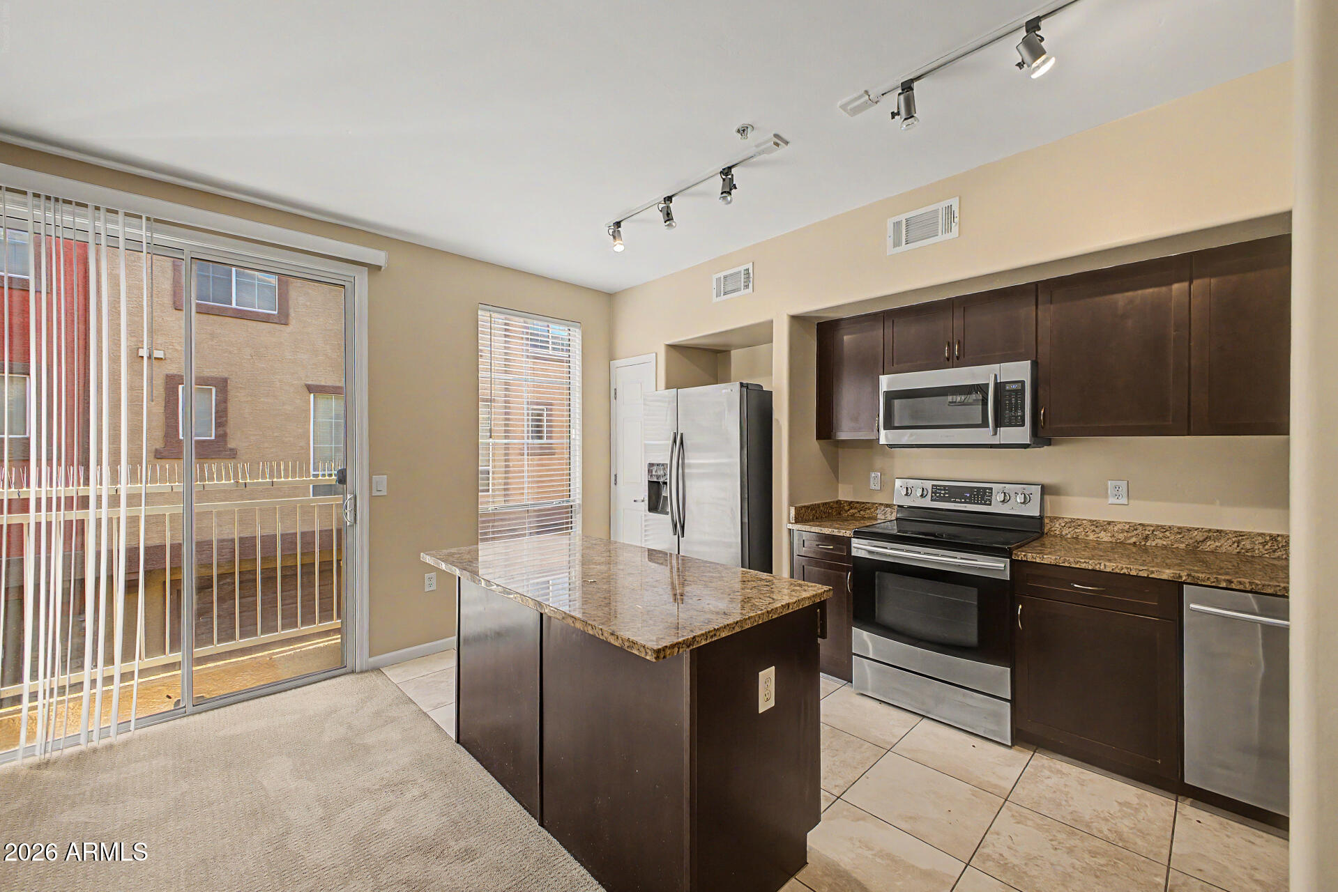 1920 East Bell Road, Unit 1173 Phoenix, AZ 85022 - Photo 8 of 33 a large kitchen with stainless steel appliances granite countertop a stove top oven a sink dishwasher a dining table and chairs with wooden floor