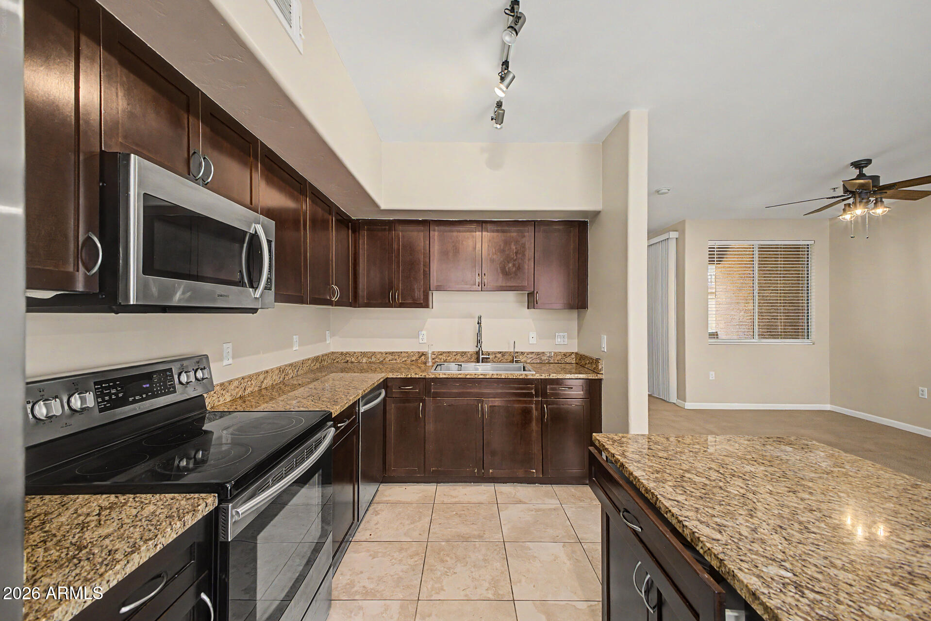 1920 East Bell Road, Unit 1173 Phoenix, AZ 85022 - Photo 9 of 33 a kitchen with stainless steel appliances granite countertop wooden cabinets a stove top oven a sink and dishwasher