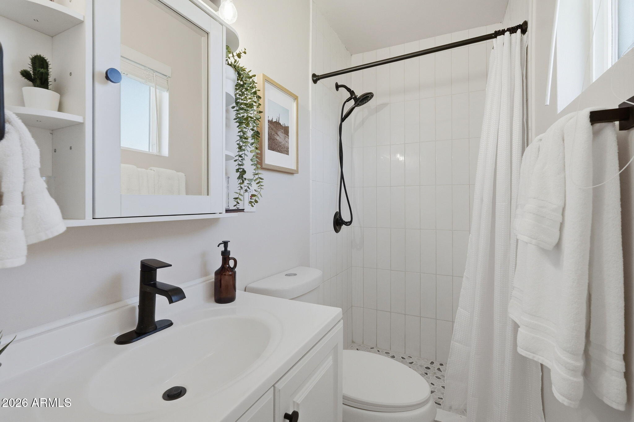 1052 West Elna Rae Street Tempe, AZ 85281 - Photo 11 of 16 a bathroom with a sink toilet and shower